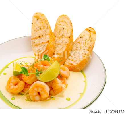 Shrimp dish with lime and bread served in a simple setting 140594182