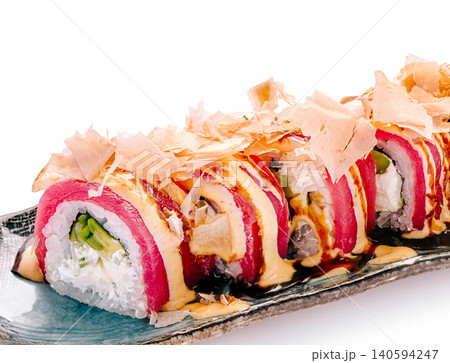 Sushi roll placed on a long plate with toppings arranged in a line Sushi roll placed on a long plate with toppings arranged in a line 140594247