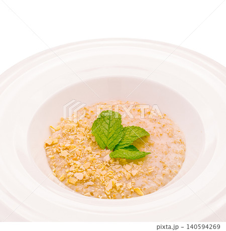 Delicious dish featuring oats with mint on a white plate in a simple setting 140594269
