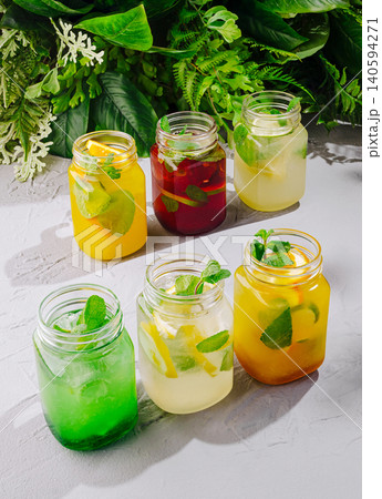 Colorful drinks in jars with fresh ingredients on a gray surface 140594271