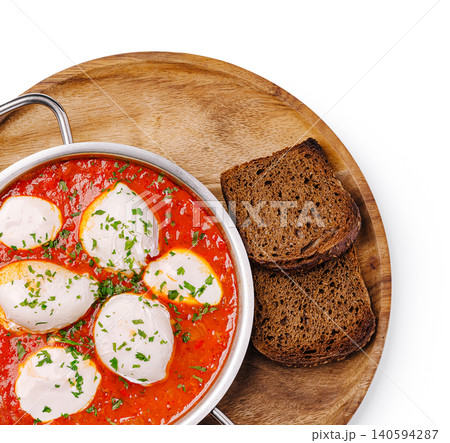 Delicious dish served with bread on a wooden board in bright setting 140594287