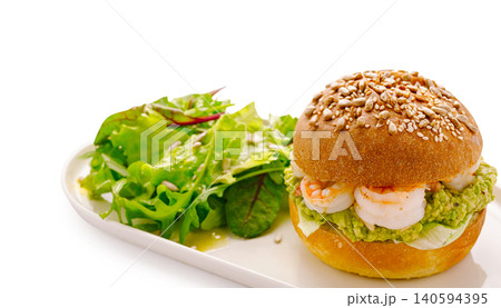 Shrimp sandwich with sesame seed bun and salad on a plate Shrimp sandwich with sesame seed bun and salad on a plate 140594395