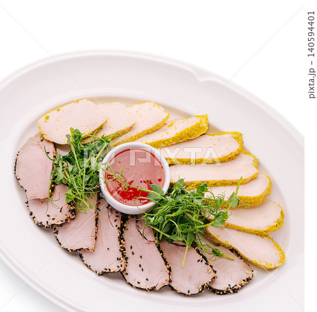 Delicious sliced meats served with dipping sauce on a white plate Delicious sliced meats served with dipping sauce on a white plate 140594401