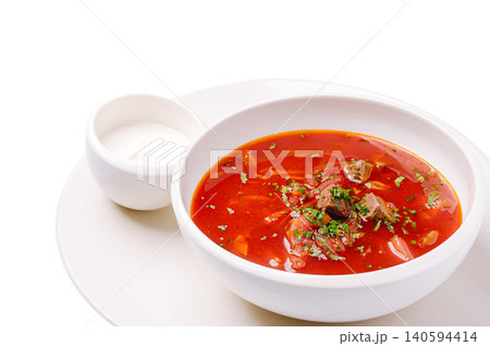 Bowl of soup with herbs and cream served on white plate Bowl of soup with herbs and cream served on white plate 140594414