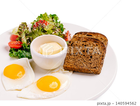 Breakfast meal with eggs, salad, bread, and butter on a white plate Breakfast meal with eggs, salad, bread, and butter on a white plate 140594562