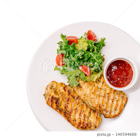 Grilled chicken with salad and dipping sauce served on a white plate Grilled chicken with salad and dipping sauce served on a white plate 140594600