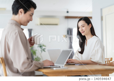 リビングでテレワークをするミドルの夫婦 リビングでテレワークをするミドルの夫婦 140594647