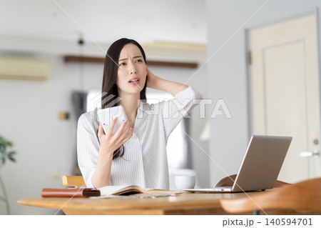 リビングで家計簿をつける女性 リビングで家計簿をつける女性 140594701