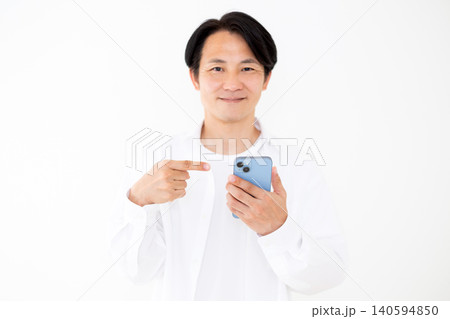 スマホを指差す白いシャツを着たミドル男性白バック スマホを指差す白いシャツを着たミドル男性白バック 140594850