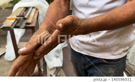 Close up of male dirty hands of adult labor at construction. Repairman rubbing unclean arms after hard work at the site. Concept of exhausting and hard work. Slow motion 140596031