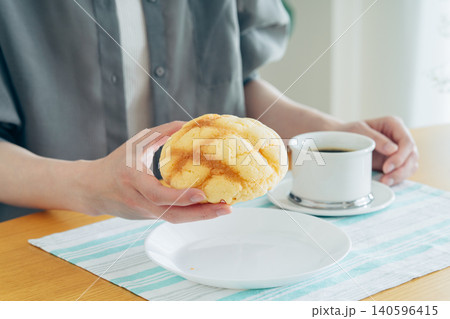 家でメロンパンを食べる若い女性 140596415