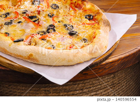Delicious baked pizza with olives, cheese, and red pepper Delicious baked pizza with olives, cheese, and red pepper 140596554