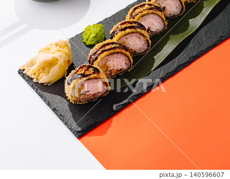 Fried tempura sushi rolls with unagi sauce, ginger, wasabi on slate 140596607