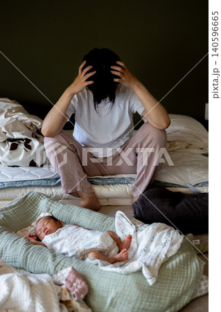 育児に疲れて頭を抱える若い母親 140596665