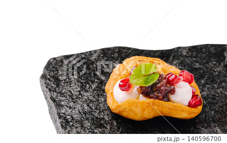 Gourmet profiterole appetizer with pomegranate seeds on slate 140596700