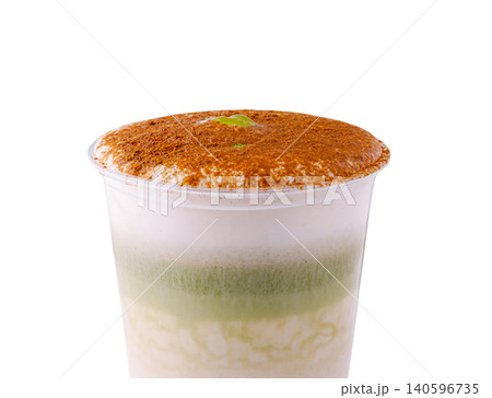 Layered iced matcha latte with cinnamon powder topping 140596735