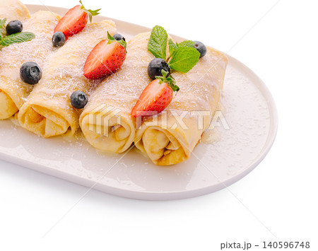 Rolled pancakes with fresh berries and mint leaves 140596748