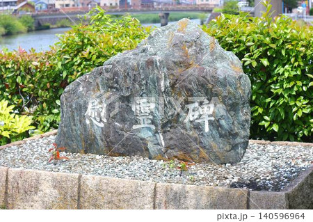 河川の近くに建立された「慰霊碑」の文字が刻まれた天然石の石碑 河川の近くに建立された「慰霊碑」の文字が刻まれた天然石の石碑 140596964