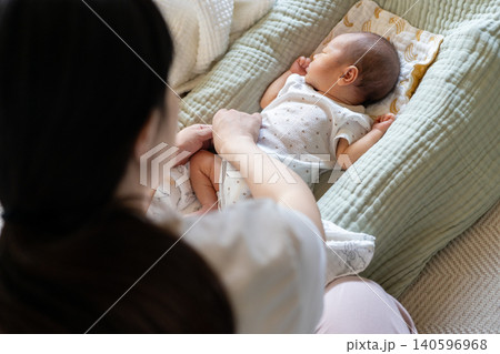 新生児を着替えさせている母親の手元 140596968