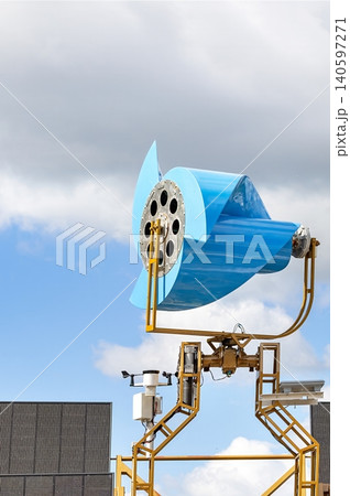 Wind turbine in a clear sky near a modern building in an industrial area Wind turbine in a clear sky near a modern building in an industrial area 140597271