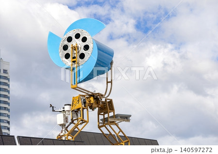 Unique wind turbine design on building with solar panels under cloudy sky 140597272