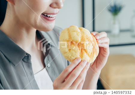 家でメロンパンを食べる若い女性 家でメロンパンを食べる若い女性 140597332