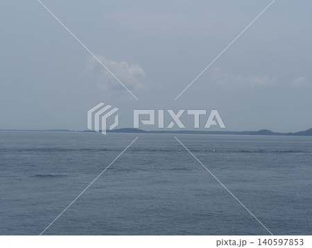Calm sea horizon cloudy sky distant island tranquil seascape with calm water under overcast sky Calm sea horizon cloudy sky distant island tranquil seascape with calm water under overcast sky 140597853