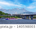 Pink cruise ship on a wide river under beautiful blue sky with majestic mountains 140598003