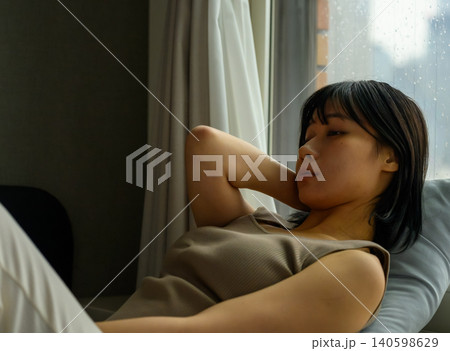 窓辺でくつろぐ若い女性 窓辺でくつろぐ若い女性 140598629