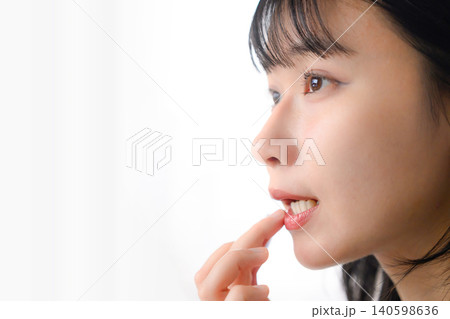 指を口元に添える若い女性 指を口元に添える若い女性 140598636
