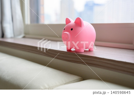 窓辺の棚にあるピンクの貯金箱 140598645