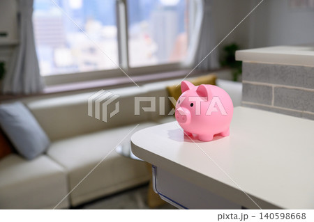 テーブルの上のピンクの貯金箱 140598668