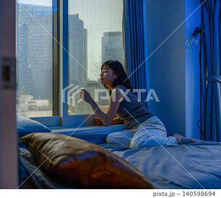 雨の夜、窓の外を眺める女性 雨の夜、窓の外を眺める女性 140598694