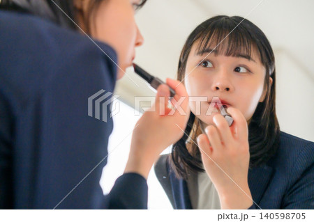 鏡の前で口紅を塗る女性 鏡の前で口紅を塗る女性 140598705