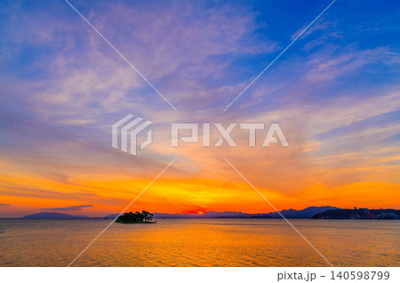 夕暮れの宍道湖 地平線に沈みゆく夕日とオレンジ色に染まる静かな湖面風景 夕暮れの宍道湖 地平線に沈みゆく夕日とオレンジ色に染まる静かな湖面風景 140598799
