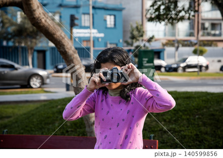 A girl wearing a pink sweater is taking a picture of herself A girl wearing a pink sweater is taking a picture of herself 140599856