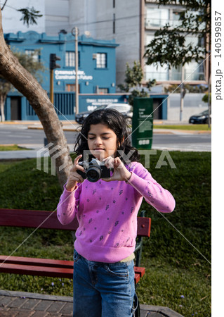 A girl wearing a pink sweater is taking a picture of herself A girl wearing a pink sweater is taking a picture of herself 140599857