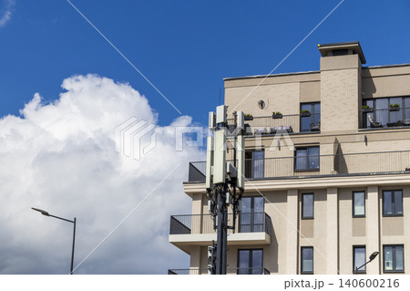 Cellular base station antennas installed next to a modern apartment building 140600216