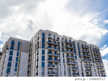 Modern apartment building facade with balconies against a blue sky Modern apartment building facade with balconies against a blue sky 140600717