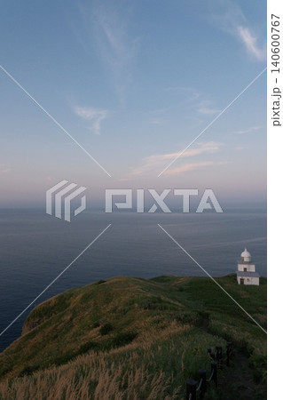 夕暮れの光に照らされる海辺の灯台 140600767