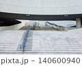 Modern concrete building architecture with wide stone stairs and metal railings 140600940
