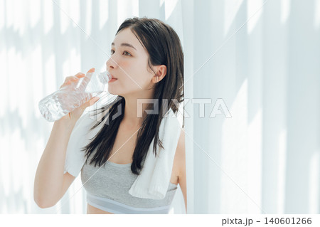 窓際で水を飲む女性 140601266