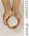 Female hands holding tender white flower. Close up. 140602235