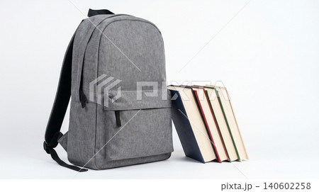 Grey fabric backpack standing beside stack of books with backpack education literature academic learning university backpacking textbook hardcover knowledge isolated background textiles Grey fabric backpack standing beside stack of books with backpack education literature academic learning university backpacking textbook hardcover knowledge isolated background textiles 140602258