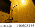 電球の温かい光が包み込むノスタルジックなタイル貼りの浴室 140602386