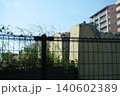 青空の下で雑草が生い茂るコンクリートの古い崩壊壁とフェンス 140602389