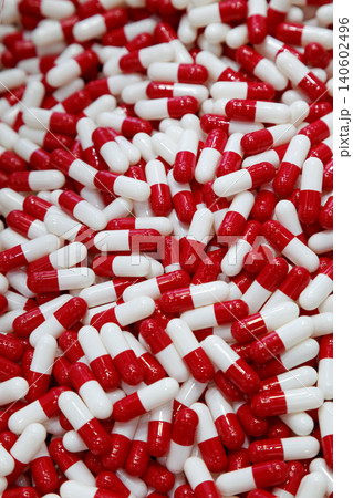 red and white medicine pill capsules waiting to be pack or filling at the container in medical factory. healthcare, pharmaceutical industry, medical treatment, prescription drugs, pharmacy, vitamin 140602496