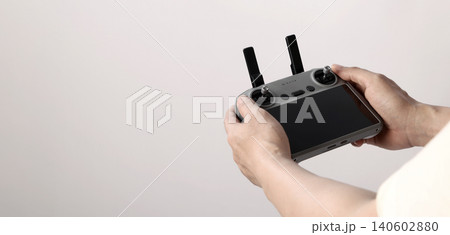 Drone camera. Modern camera drone with remote controller on white background. UAV or Unmanned Aerial Vehical technology for aerial photography videography mapping inspection and recreational flying. Drone camera. Modern camera drone with remote controller on white background. UAV or Unmanned Aerial Vehical technology for aerial photography videography mapping inspection and recreational flying. 140602880