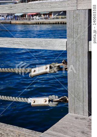 Close up steel turnbuckle and Wire Rope Assemble as railing. Steel Wire Rope Sling and metal cable clamp connected with screw bolt in sideway railing. Close up steel turnbuckle and Wire Rope Assemble as railing. Steel Wire Rope Sling and metal cable clamp connected with screw bolt in sideway railing. 140603388