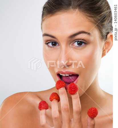 Woman, portrait and raspberry with eating in studio for wellness detox, healthy body and nutrition diet. Model, person and fruit for organic cosmetics, natural beauty and skincare on white background 140603461